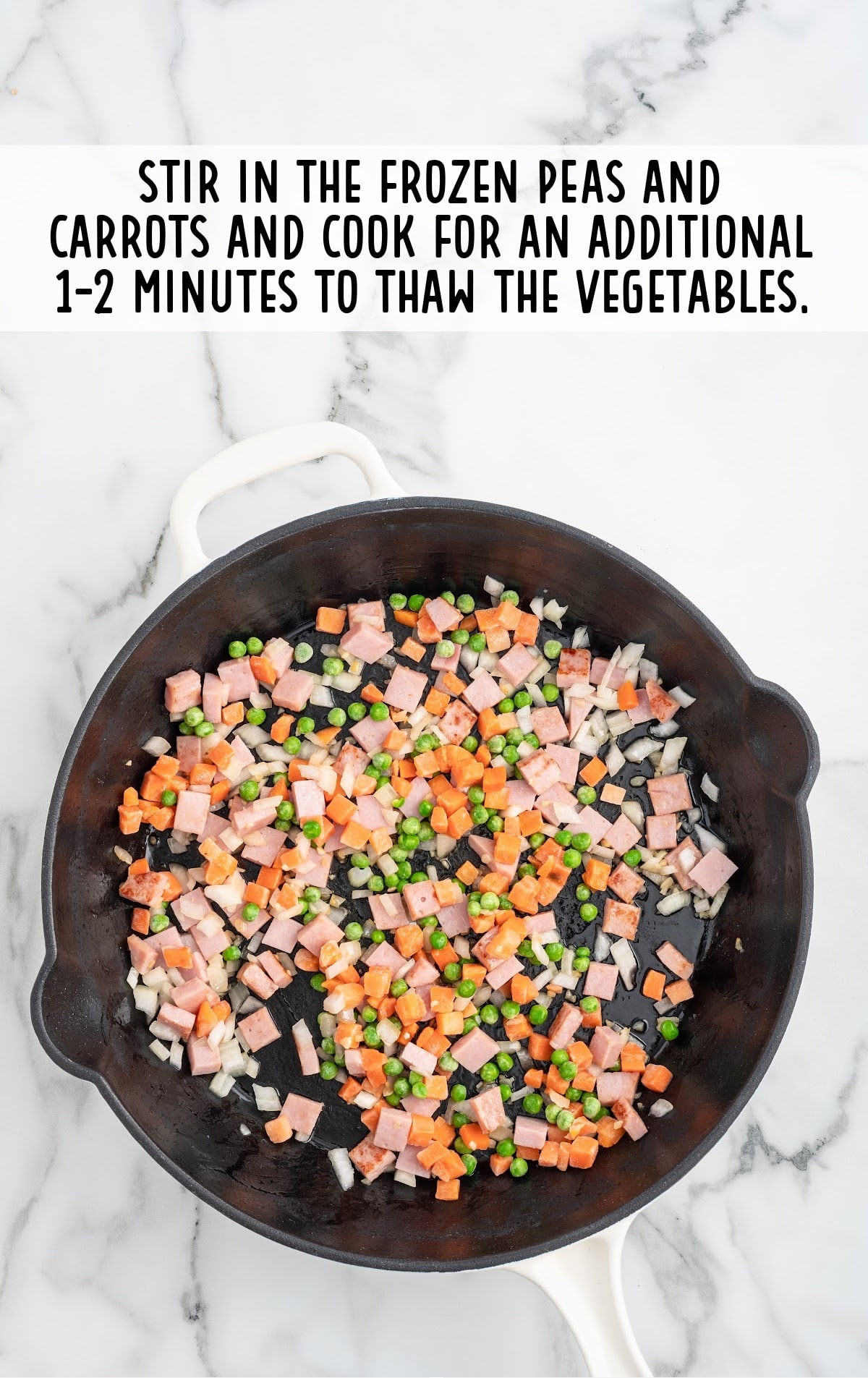 frozen peas and carrots added to the skillet of ham