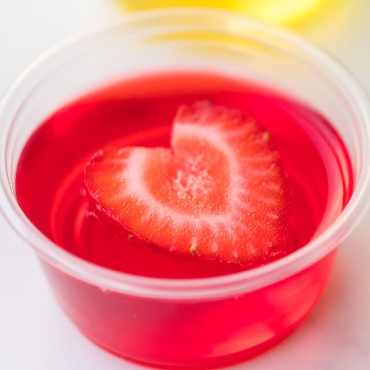 strawberry jello shot in 2 ounce plastic cup