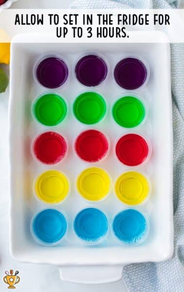 vodka jello shots lined up in 2 ounce plastic cups by color