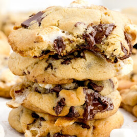 A stack of marshmallow cookies split open with ooey gooey melted chocolate and marshmallows