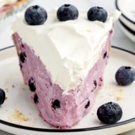 Slice of blueberry pie on a dessert plate.