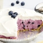 Sliced blueberry pie in a pie plate.