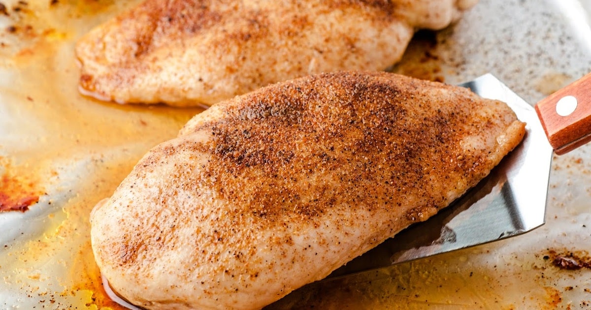 close up shot of a Oven Baked Chicken sliced on a wooden board