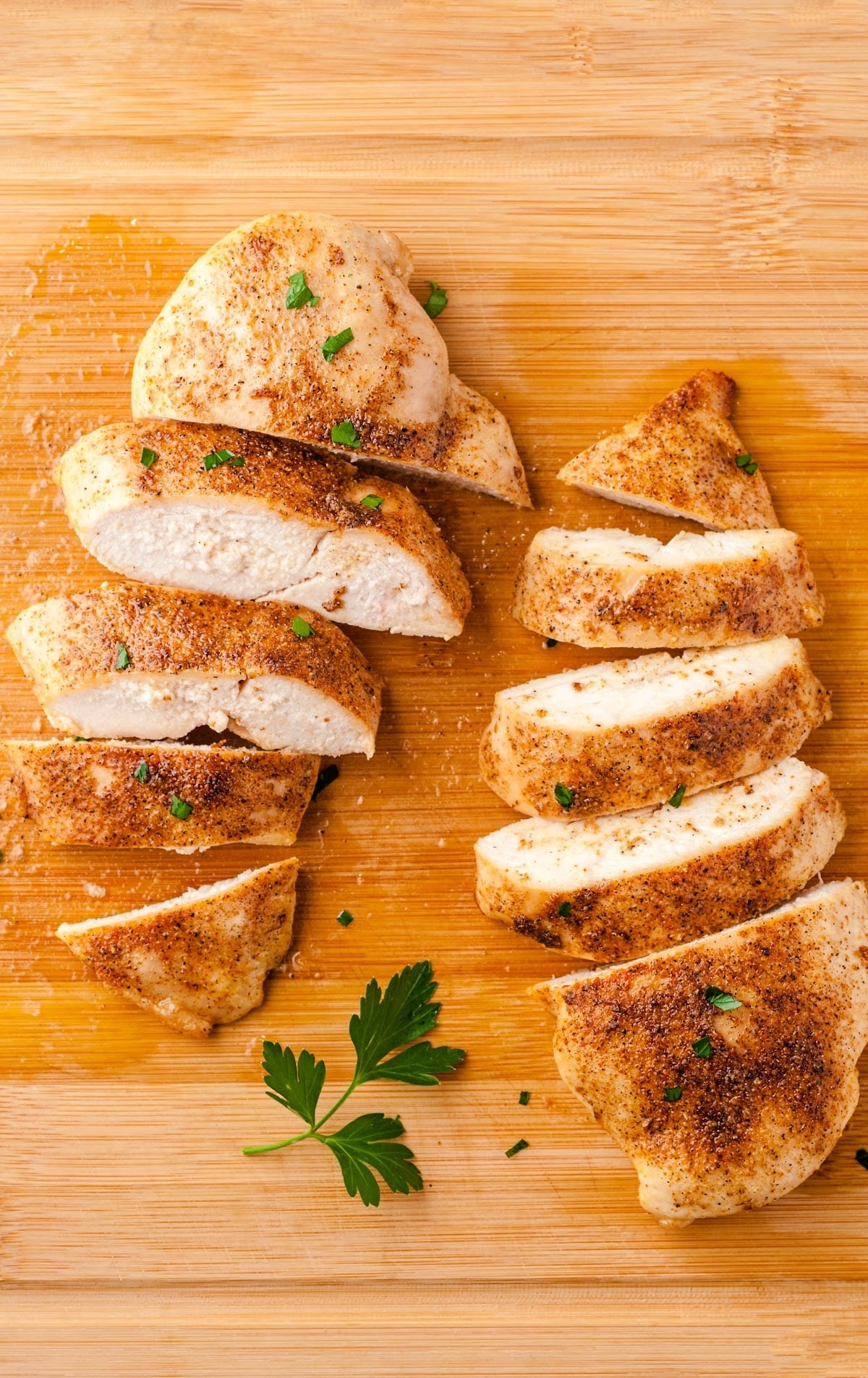 close up shot of a Oven Baked Chicken sliced on a wooden board