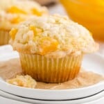 Close up of a peach cobbler muffin on a white serving plate