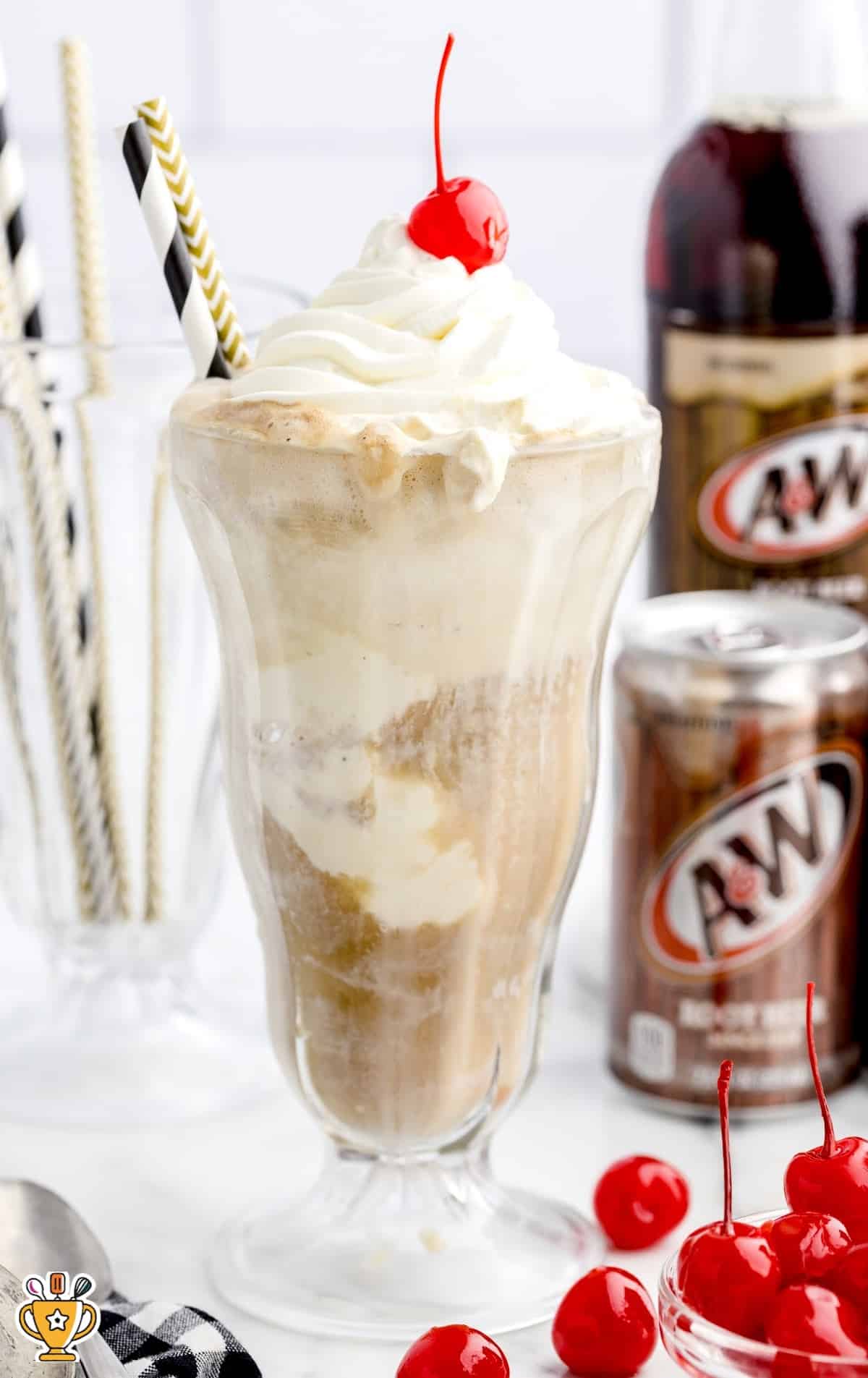 close up shot of glasses of Chocolate Milkshake topped with whipped cream then garnished with Hershey bars, a cherry, chocolate sprinkles, and chocolate syrup