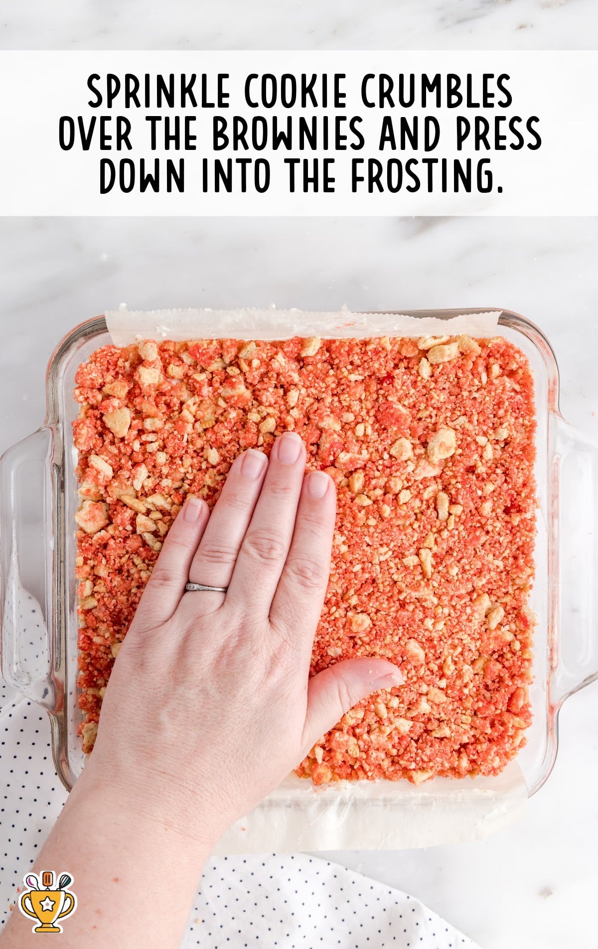 cookies crumbles over the strawberry brownies in a baking dish