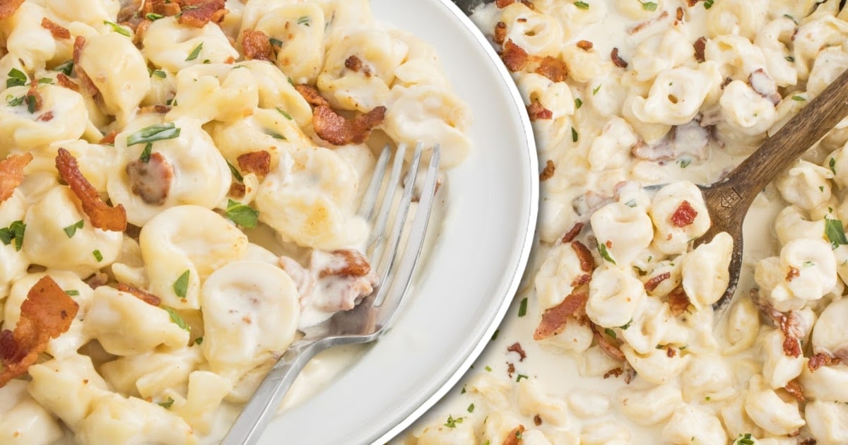 overhead shot of a wooden spoon grabbing a piece of Tortellini Carbonara