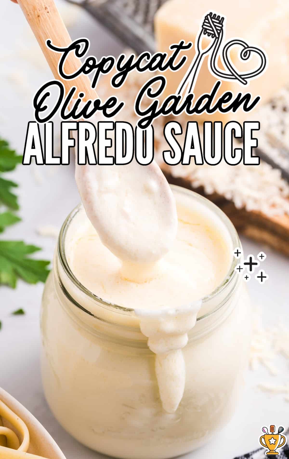 close up shot of a jar of Copycat Olive Garden Alfredo Sauce with the sauce being scooped out with a spoon