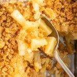 a overhead shot of Pineapple Casserole with a spoon grabbing a piece