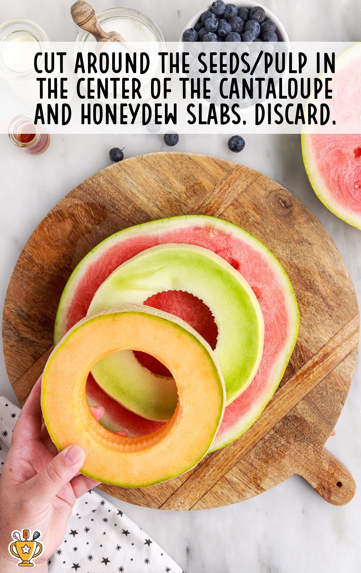 cut around the seed/pulp in the center of the cantaloupe and honeydew slabs on a cutting board