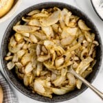 A serving dish of air fryer onions with a spoon.