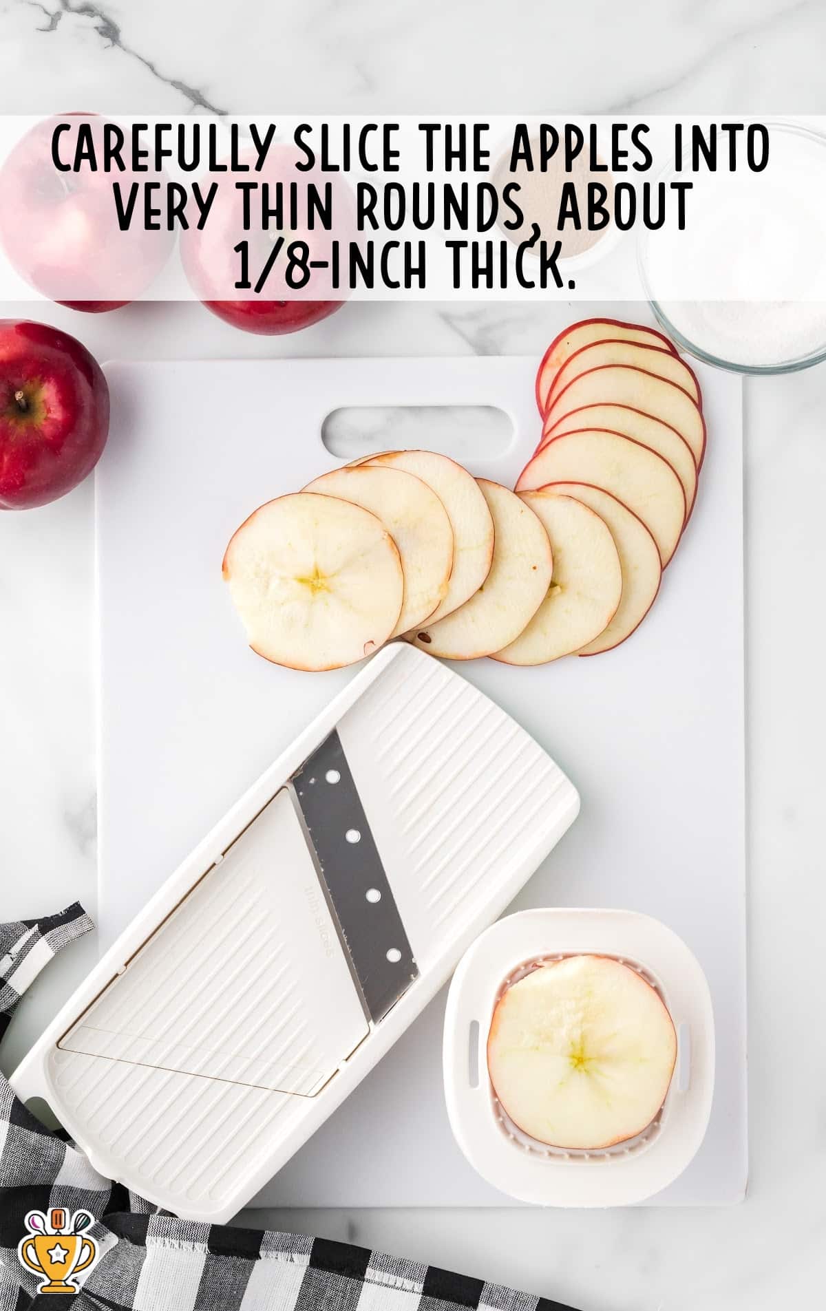 apple slices on a cutting board with a mandolin.