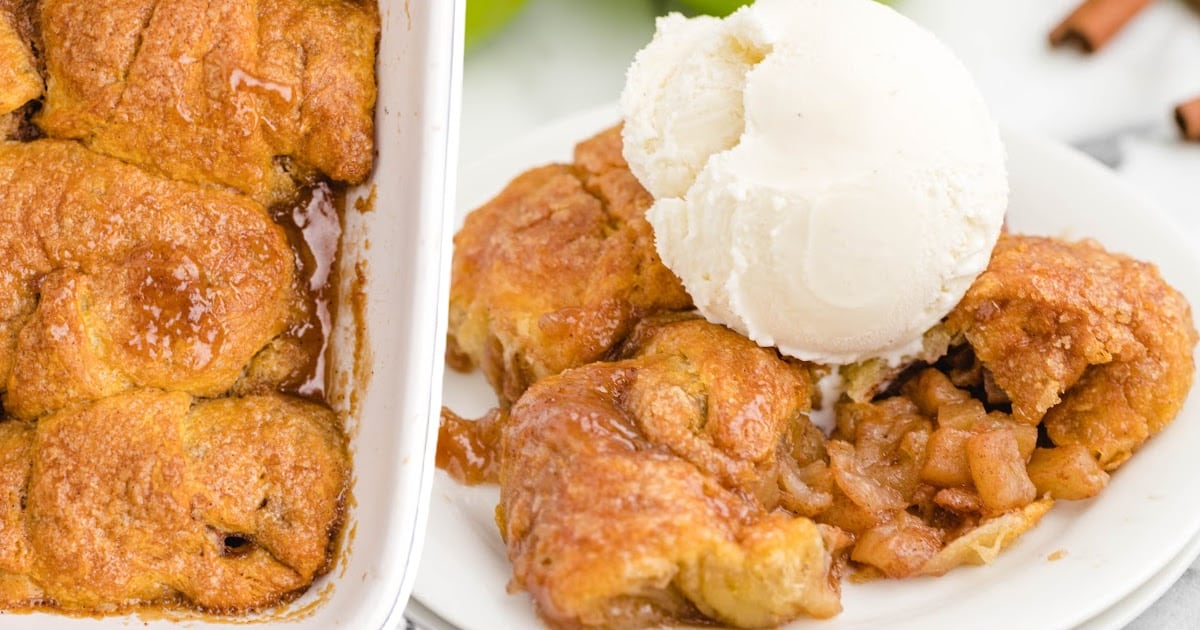 An overhead view of the pan of apple dumplings beside a white plate with more dumplings and ice cream.