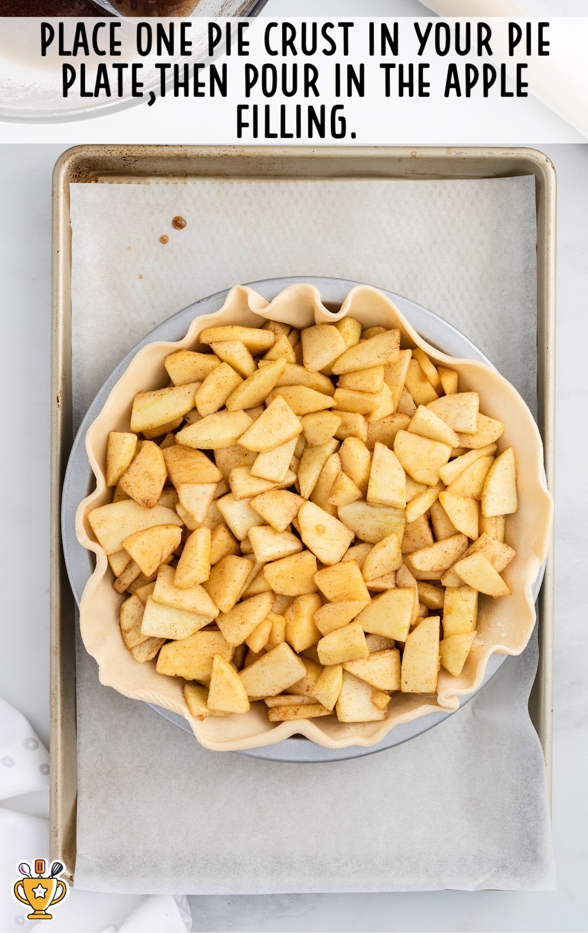 A Pie crust put on a pie plate with apple slices in it