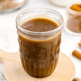 a jar of sauce on a cutting board.