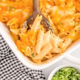 a serving spoon scooping up pasta from a baking dish