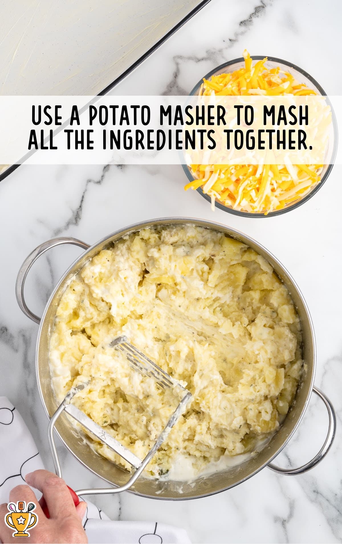 Mashed Potato in a pan with a masher in it