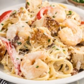 a white plate covered in a carbonara pasta.