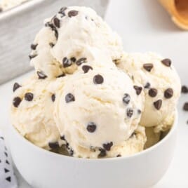 a white ice cream bowl with plenty of scoops of ice cream inside.