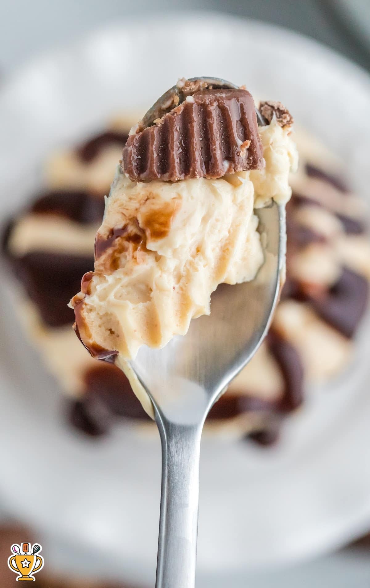 A spoon holding a piece of Mini Peanut Butter Cheesecake