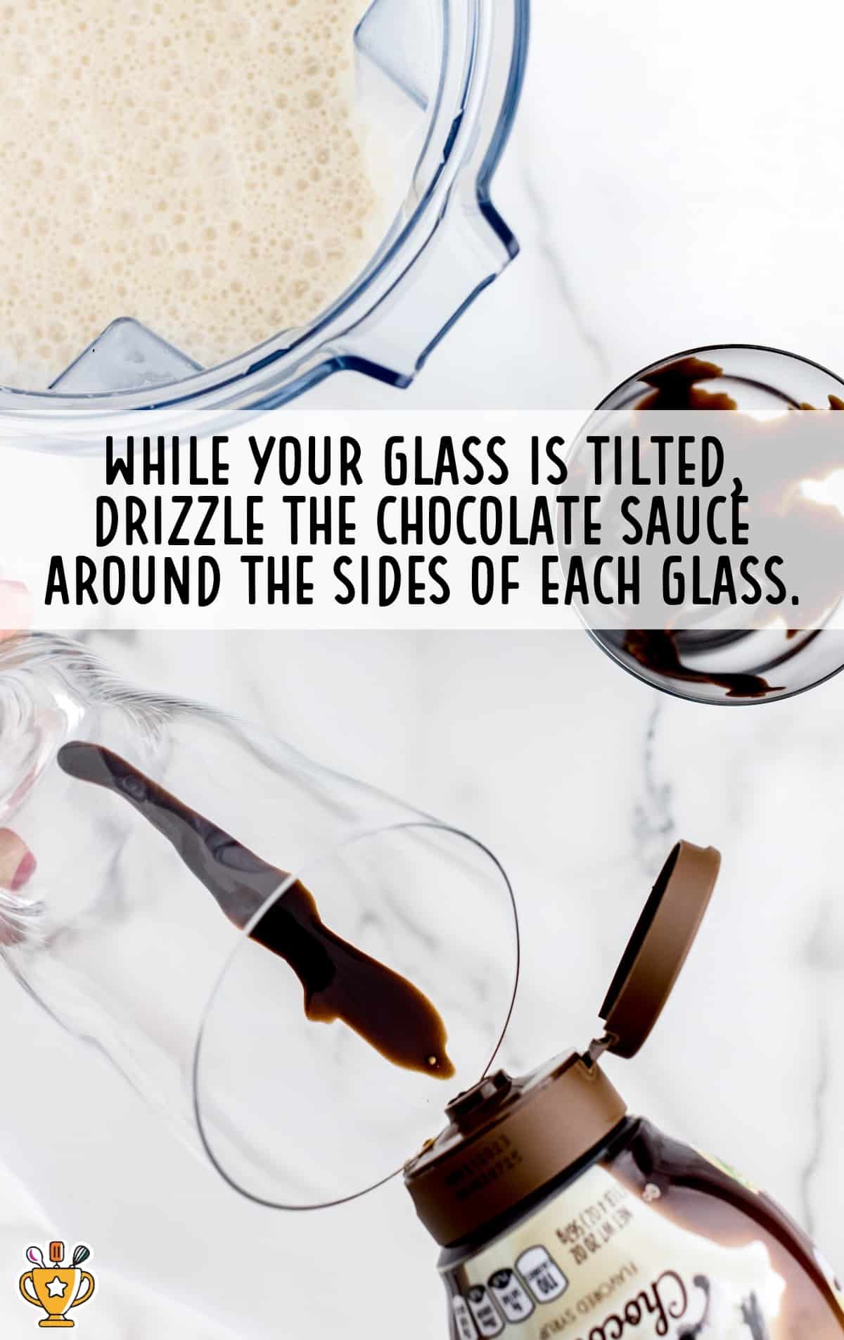 A glass with a drizzle of chocolate sauce on the side