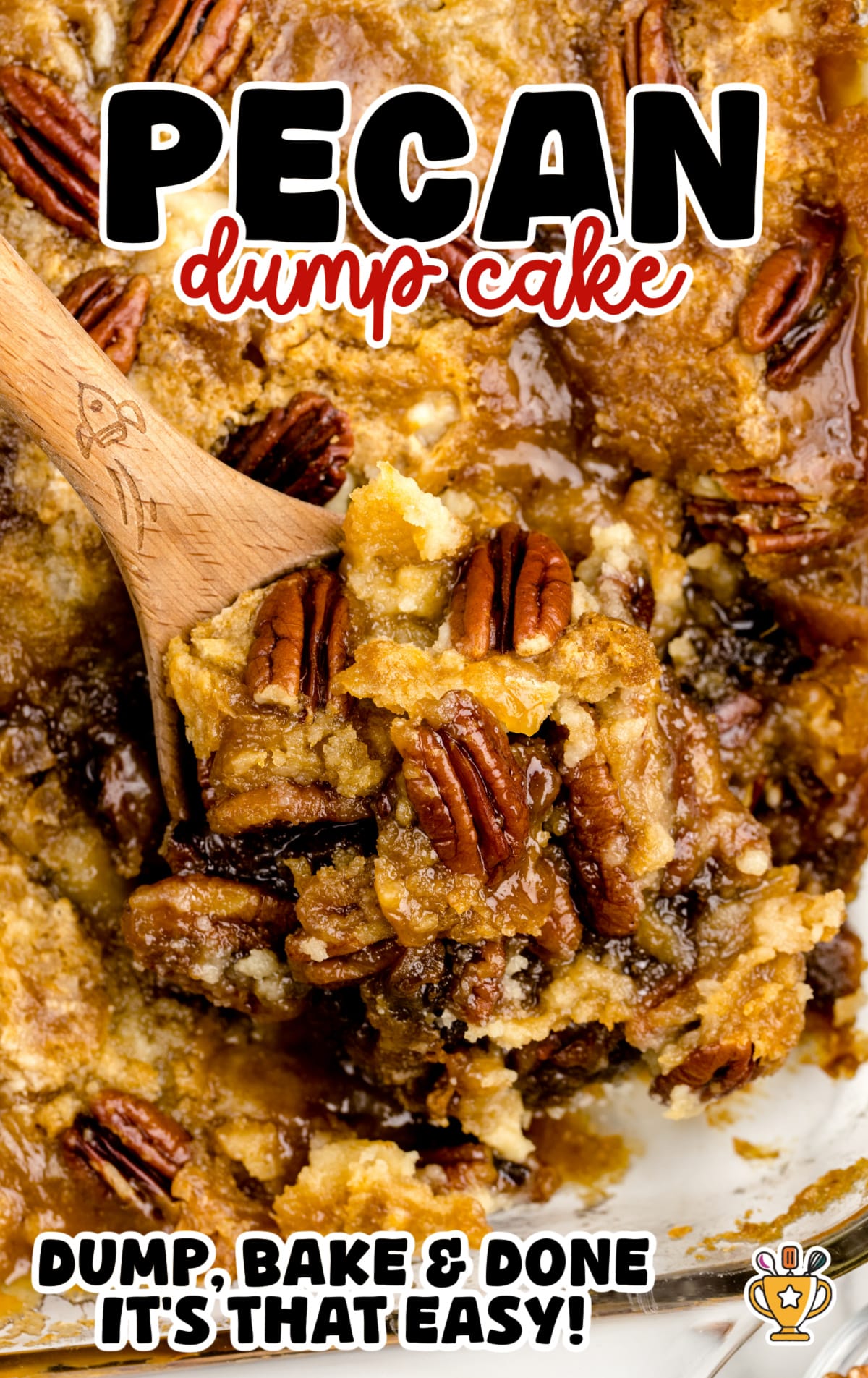 Close-up of a wooden spoon lifting a gooey scoop of pecan dump cake from a glass baking dish, showing golden brown cake, caramelized edges, and toasted pecans.
