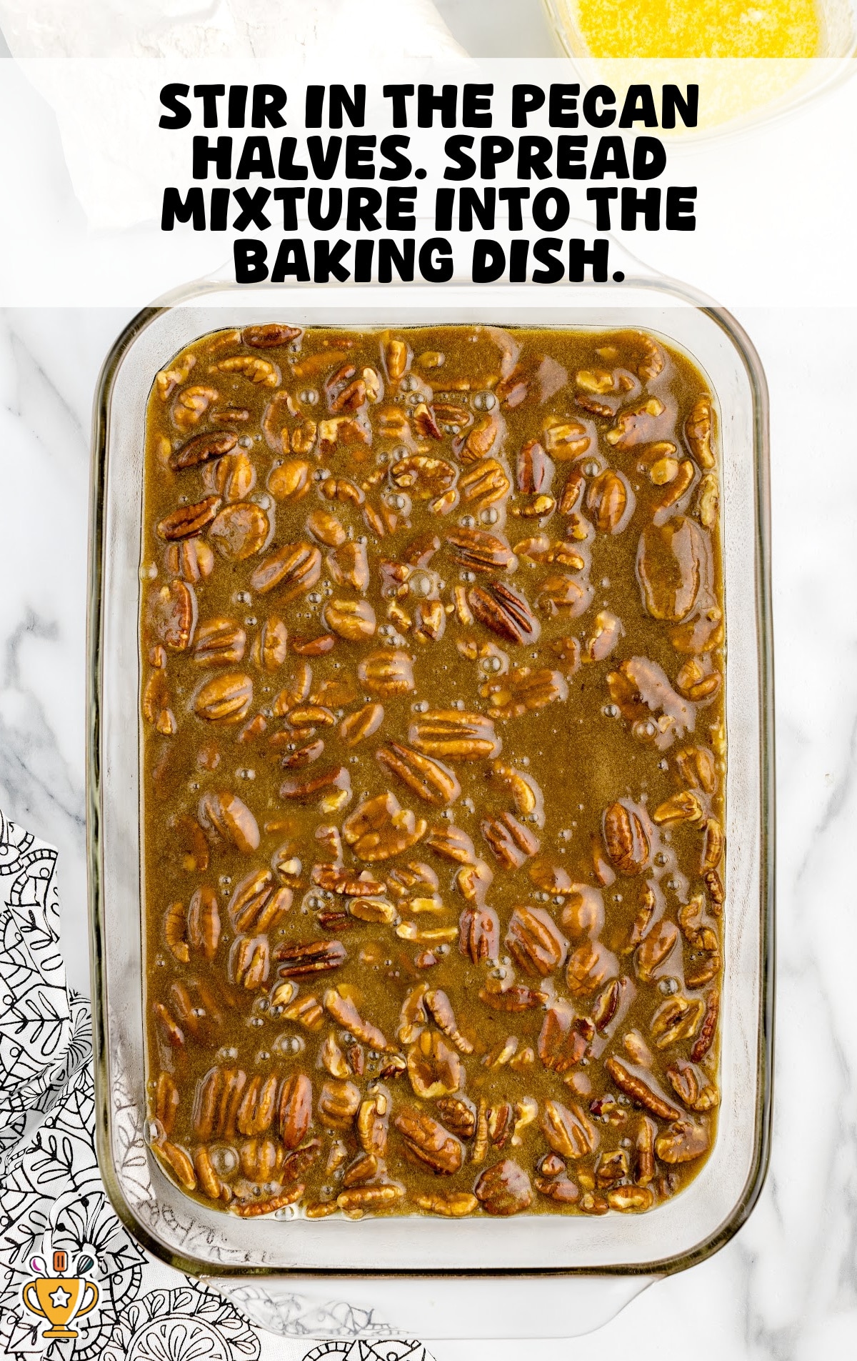 Glass baking dish filled with unbaked pecan dump cake mixture, showing a brown sugar, butter, and pecan filling spread evenly before baking.