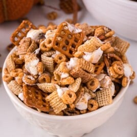 A white bowl filled with Pumpkin Spice Chex Mix in a bowl