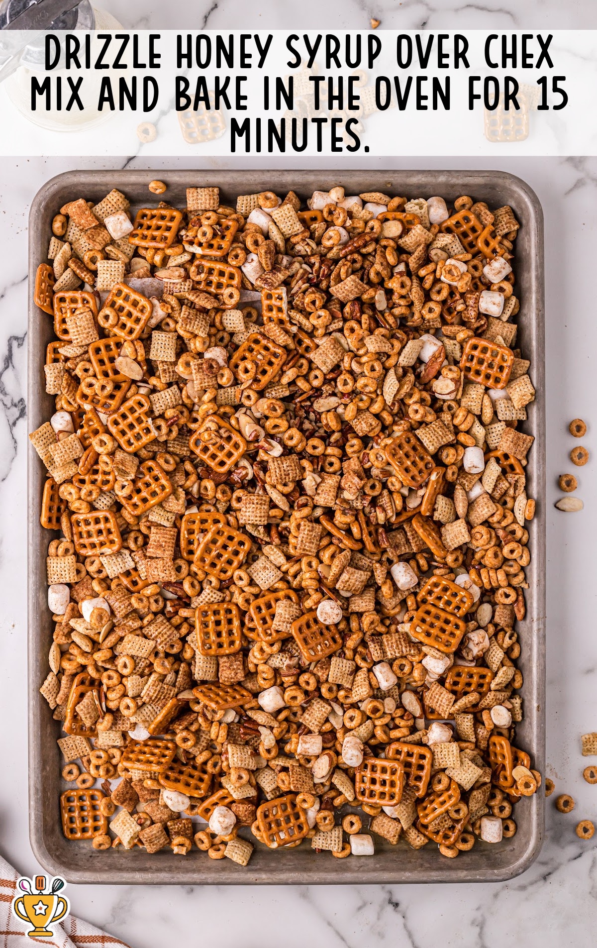 Pumpkin Spice Chex Mix in a baking pan drizzled with honey syrup ready for baking