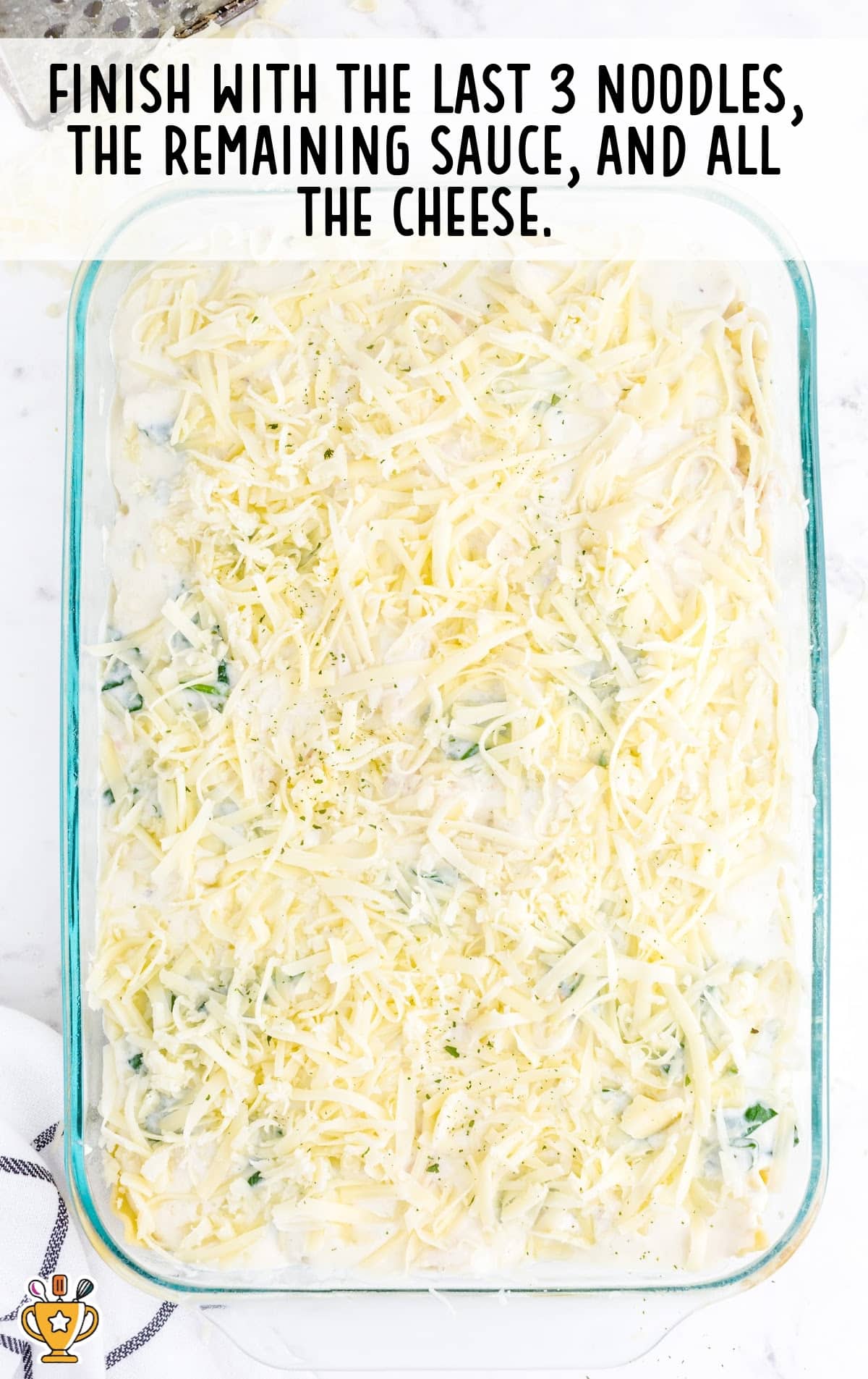 Noodles and cheese in a clear glass baking pan