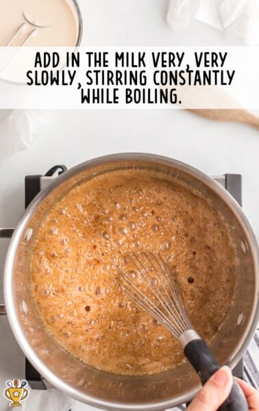hand whisking caramel mixture in a saucepan during cooking process