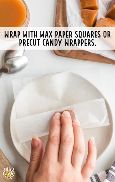 hand wrapping individual caramel piece in wax paper for storage or gifting