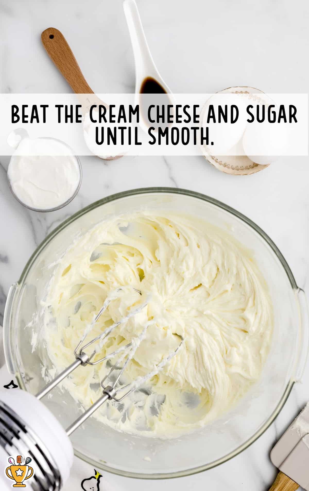 A mixture of Cream Cheese and sugar in a bowl with a mixer in it