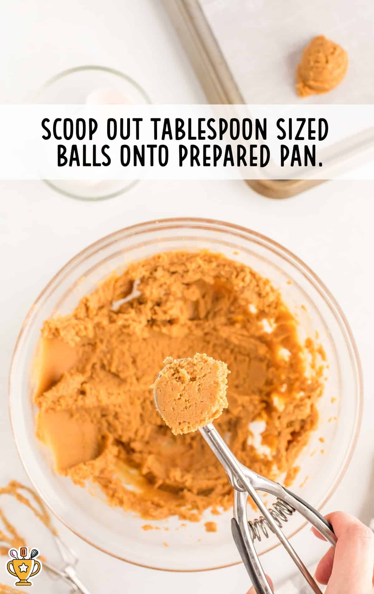 A scoop taking out 3 Ingredient Peanut Butter Cookies balls onto a prepared pan