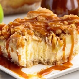 An Apple Cheesecake Bar on a plate with a bite on it