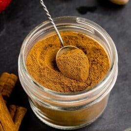 A small jar of spices with a spoon.