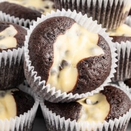 A bunch of black bottom cupcakes stacked.