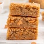 a stack of three butterscotch brownies on a white plate.