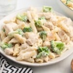 a white dinner plate full of Chicken broccoli alfredo.