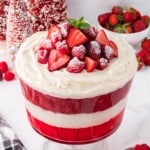 A trifle bowl of Christmas Trifle garnished with whipped cream and berries.