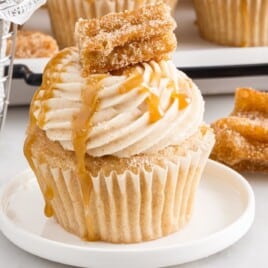 A churro cupcake on a white plate.