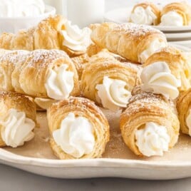 a white serving platter full of cream horns.