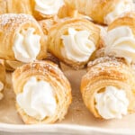 a bunch of cream horns on a serving plate