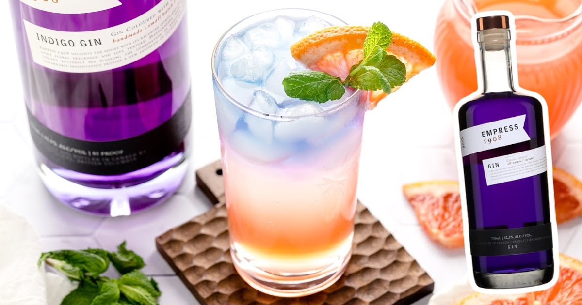 A glass of Empress Gin Cocktail with a bottle of gin beside it