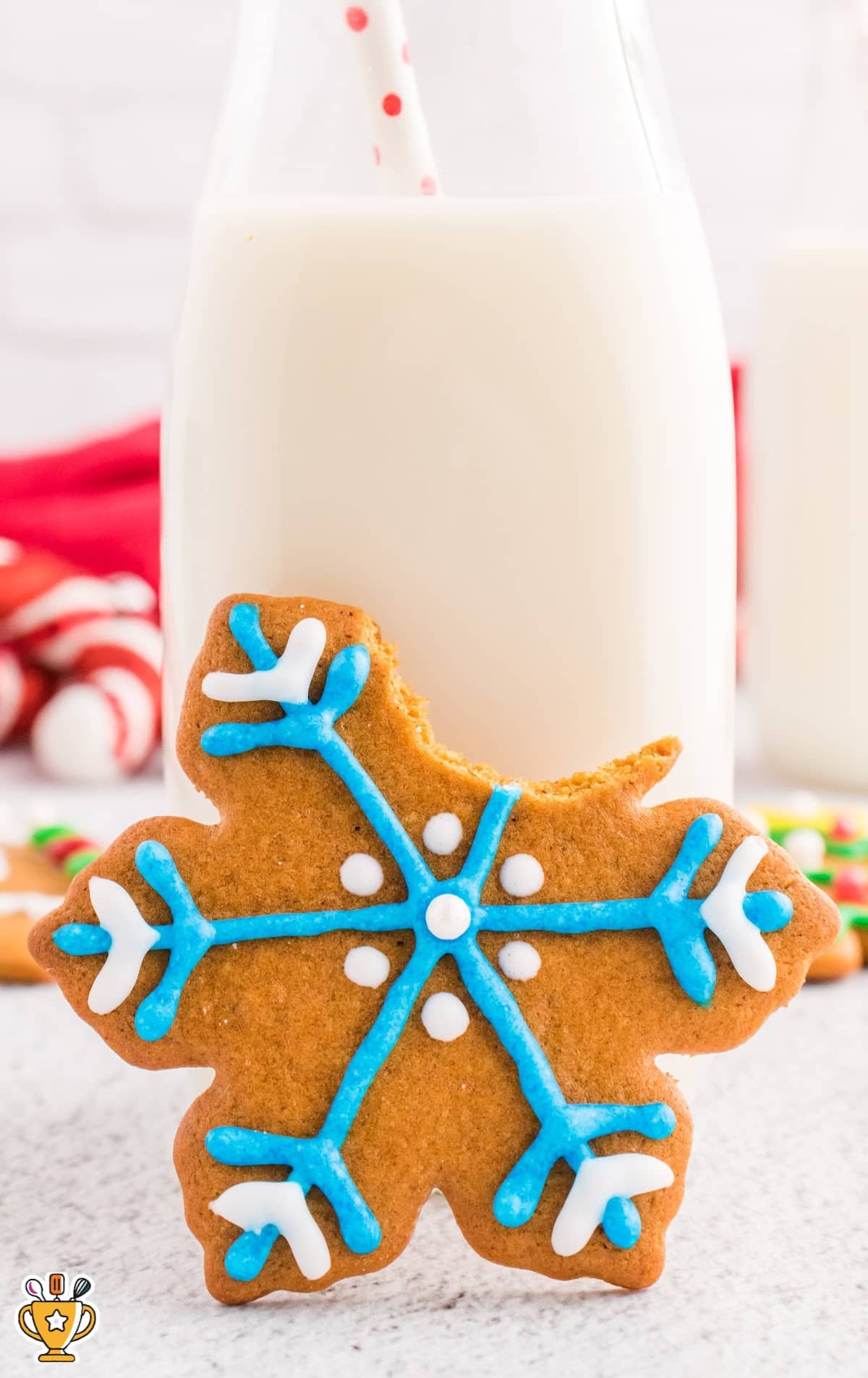 A Gingerbread Cookie with a glass of milk at the back