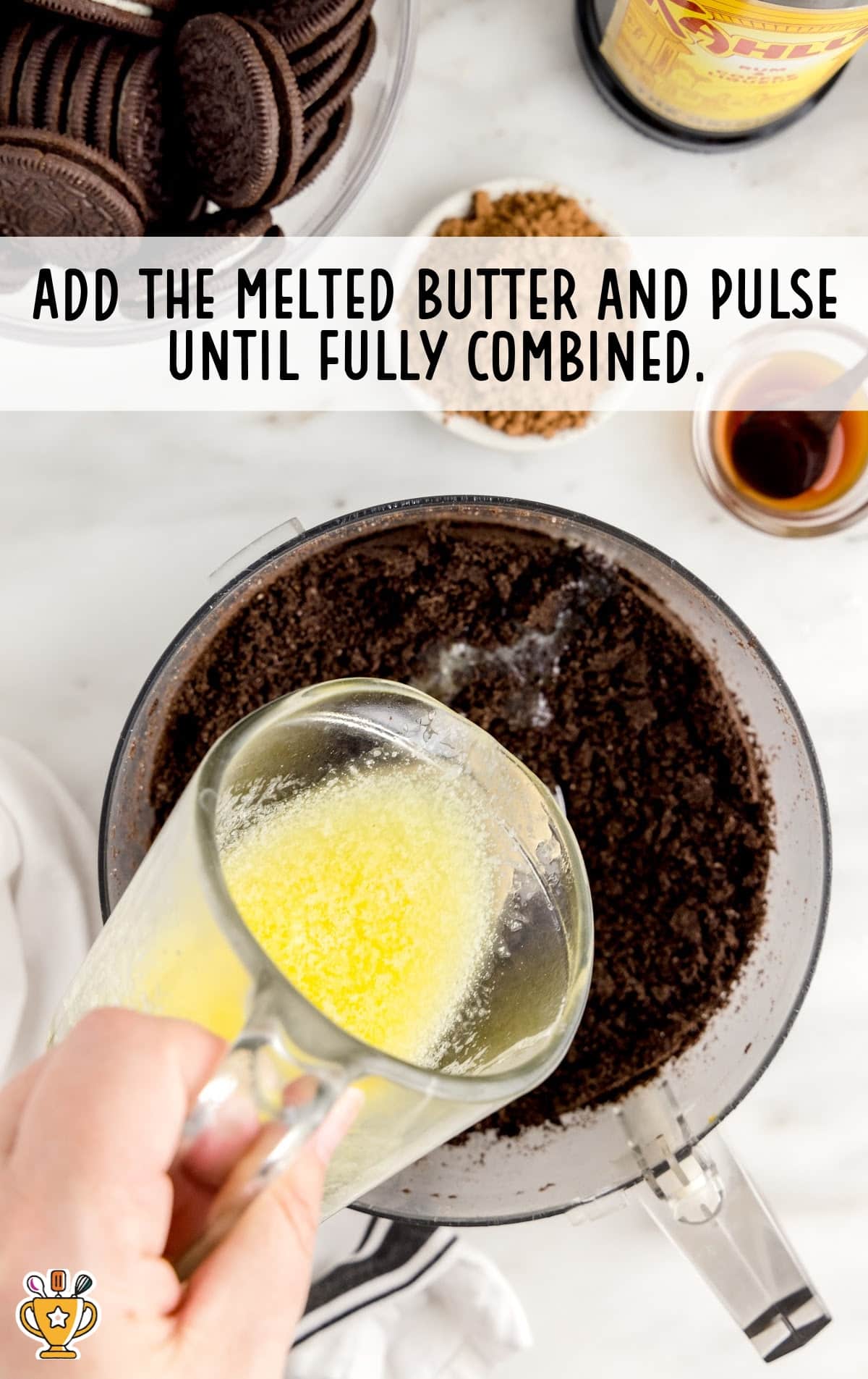 melted butter being poured in blended oreo cookies