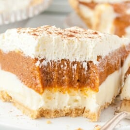 Close-up of no bake pumpkin pie with creamy layers, whipped topping, and graham cracker crust.