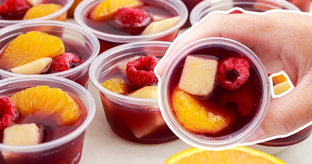 A hand holding a Sangria Jello Shot cup