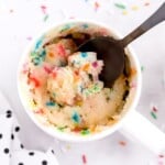 A photo of Vanilla Mug Cake in a mug from above, with a spoon in it